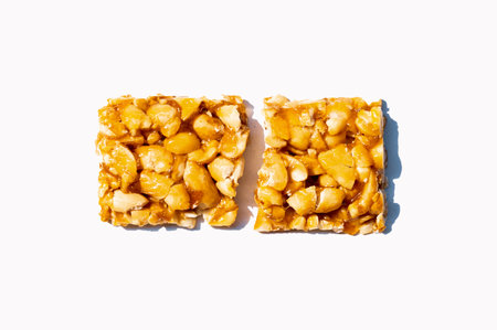 Crispy peanut brittle isolated on white background. Top view.