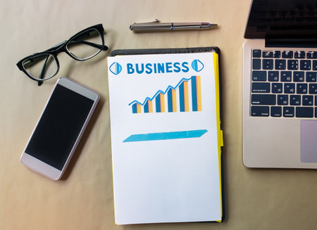 Business plan on a notepad with laptop, smartphone and glasses.の素材