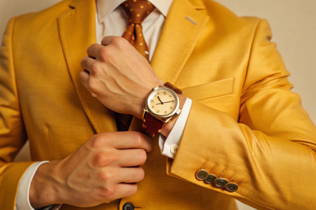 Close up of a man wearing a yellow suit with a wristwatchの素材