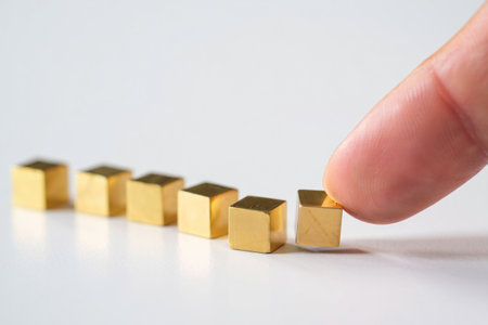 Metal cubes line. Golden cubes. Index finger touching. Choice selection. Concept.の素材