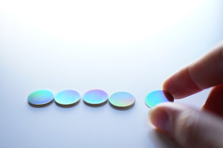 Holographic discs placed. Showing iridescent surface and white background.の素材