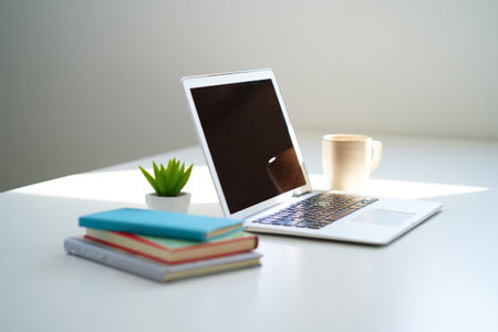 Modern laptop desk setup with books and mug for coffee. Technology workplace work from home.の素材