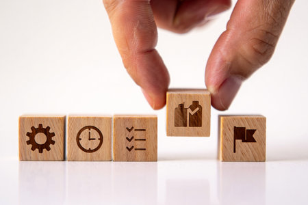 Arranging wooden blocks symbolizing steps toward goal achievement.の素材