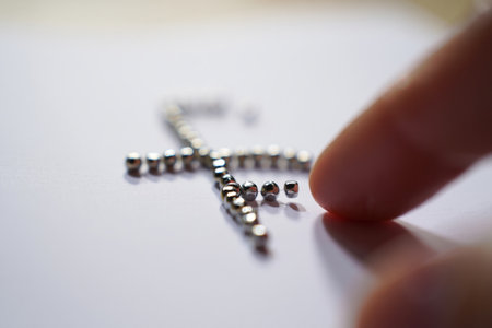 Metal balls picked by finger. Cross formation design. Minimalism and fine motor skills.の素材