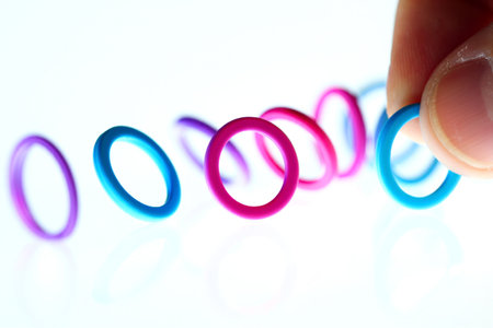 Fingers sorting rubber bands. Concept for organization. Crafting activities.の素材