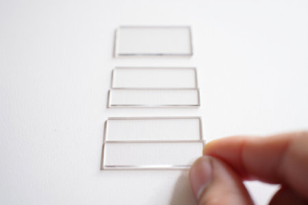 Person stacking clear glass pieces. Building blocks construction.の素材