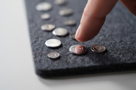 Round silver button labeled next. Electronic interface on gray felt material.の素材