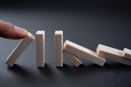 Domino effect concept. Chain reaction with blocks. Cause and effect.の素材