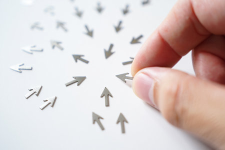 Hand selecting directional arrow. Multiple arrows aim central position.の素材