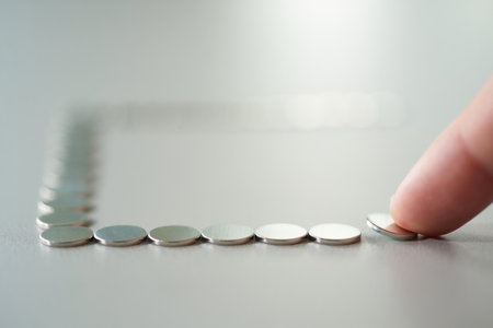 Circular silver discs with finger. Minimalism repetition concept. Geometric shape discs.の素材