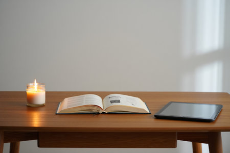 Book with candle and tablet. Study nook relaxing home reading and quiet work.の素材
