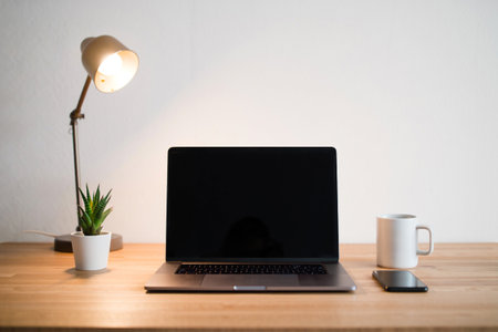 Workspace with laptop computer plant coffee mug minimalist clean designの素材