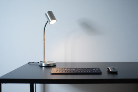 Sleek desk setup with table lamp, keyboard, and mouse. Workspaceの素材