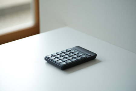 Gray numpad on table. Minimalist keypad. Modern workspace accessory.の素材