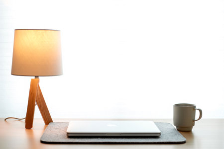 Study work office space. Laptop and lamp on table top surface.の素材