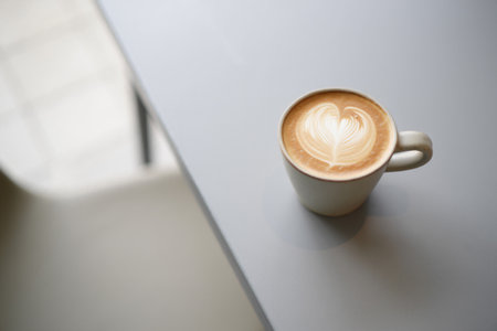 Latte art cappuccino drink served on minimalist clean gray table. Heart pattern in foam.の素材