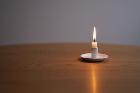 Candlelight on table. Warm cozy atmosphere and serene ambiance glow.の素材