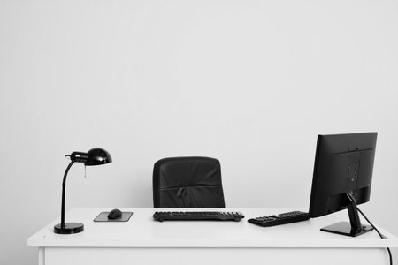 Office desk setup with computer and lamp. Professional workspace environment.の素材