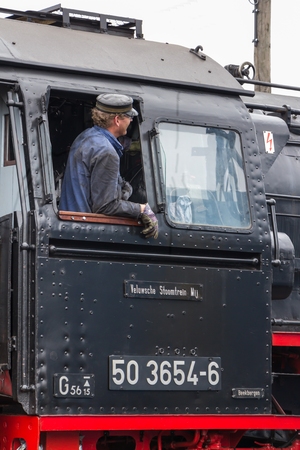 Antique steam locomotive on his way with an engineerのeditorial素材