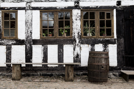 White timbered house, with  a bench and rainbarrel  in the old town Den Gamle By in Aarhus Denmarkの写真素材