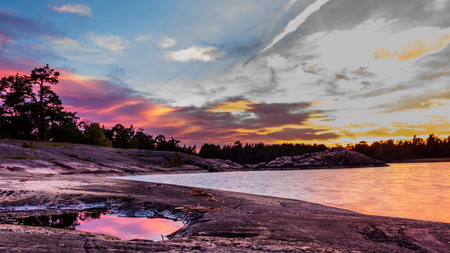 View  from the rocky coast of Sweden during sunsetの写真素材