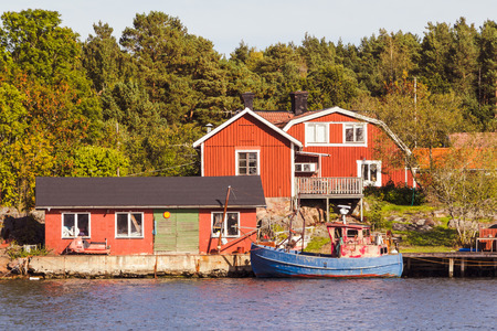Red cottages and fishing boat in south Swedenのeditorial素材