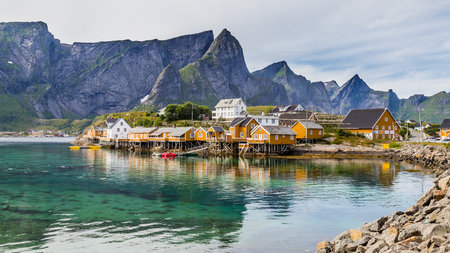 The yellow fishing village Sakrisoy peaks with snow on the background on Lofoten islands Norway.の写真素材