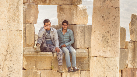 JERASH, JORDAN - APRIL 25, 2016: Two goat keepers hiding in the shade on th Roman site in Jerash Hordan.のeditorial素材