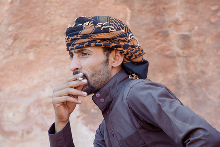 WADI RUM DESERT, JORDAN - APRIL 30, 2016:  Bedouin man in Wadi Rum smoking a cigaretteのeditorial素材