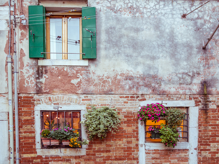 Picturesque windows with shutters and flowers in Venice, Italyの写真素材