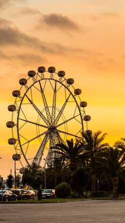 Giant white ferris wheel during sunset behind the Port Authority building in Valencia Spainの写真素材