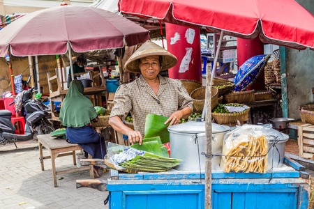 Semarng, Indonesia - November, 01, 2017: Woman selling food on a street market in Semarang, Indonesiaのeditorial素材