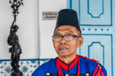 Solo, Indonesia - November, 02, 2017 Guard in tradional clothes at the entrance the colorful blue Palace of the sultan in Surakarta, Java, Indonesiaのeditorial素材
