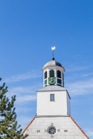 White wooden chruch tower with clock in Den Burg Texel, Netherlandsの写真素材