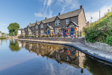 Cottages reflecting in the water of  Brecon Canal basin  in Brecon town, Brecon Beacons National Park, Wales, UKの写真素材