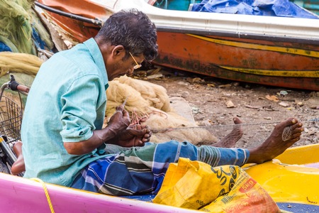 Negombo Sri Lanka July 24 2017 - Man repairing his fishing net in Negomboのeditorial素材