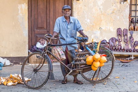Galle, Sri Lanka - August, 8, 2017: Poor old man selling coconuts in the old town of Galle in Sri Lankaのeditorial素材