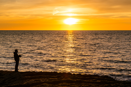 Fisherman during sunset at the tower of Bosa Marina, Sardiniaの写真素材