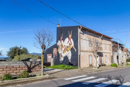 Sardinia Italy on December 27, 2019: Murals painted on houses in the streets of Tinnura depicting moments of rural and village lifeのeditorial素材