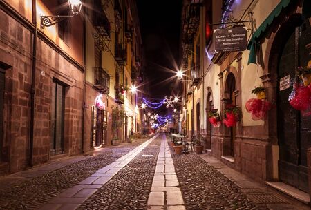 Bosa, Sardinia island Italy - December 29, 2019: Tourist relaxing during the evening in the ancient streets of Bosa, Sardinia Island, Italyのeditorial素材