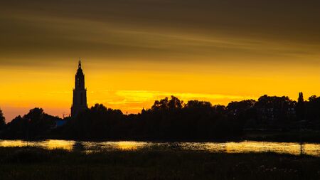 Skyline of the city of Rhenen during sunset with Cunera church and river Nederrrijn in the provence of Utrecht in the Netherlandsの写真素材