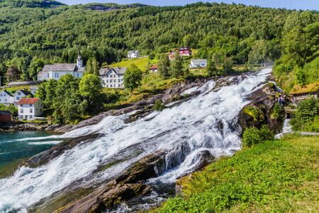 Panorama of small village Hellesylt with Hellesyltfossen waterfall in along Geiranger fjord in More og Romsdal county in Norwayの写真素材