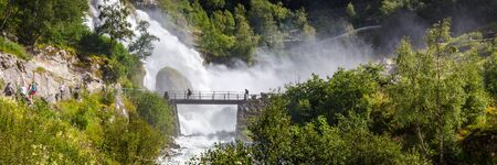 Bridge and waterfall with melting water of the Briksdal glacier in Norway, arm of Jostedalsbreen glacier in Oldedalen valley in Norway, Scandinavia.の写真素材