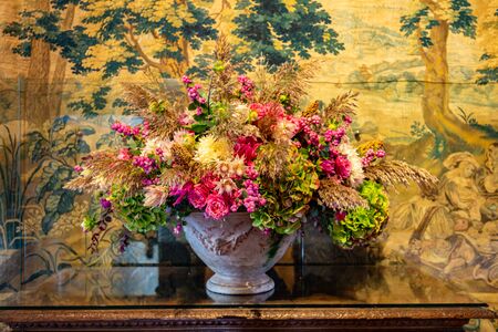 Beautiful green orange flower arrangement in autumn colors in a castle settingの写真素材