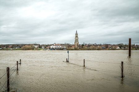 Cityscape of Rhenen during dark rainy weather with flooded Rhine river in Gelderland, Netherlandsの写真素材