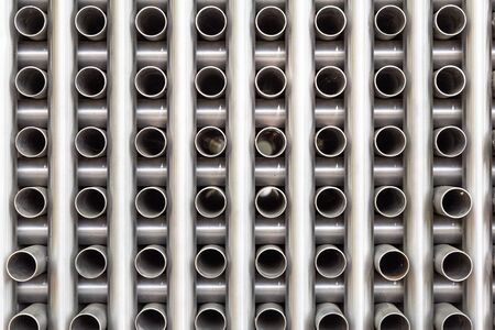 Background with a collection of stacked metal pipes
