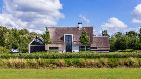 Barneveld, Netherlands- August 23, 2020: Newly build luxery white villa with thatched roof in Barneveld Hollandのeditorial素材