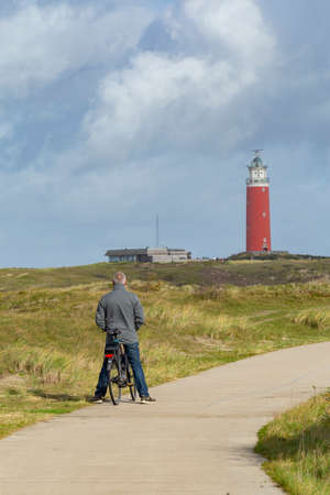 Vertical landscape with tourist enjoying the scenic view of Lighthouse at Waddenisland Texel, North Holland, Netherlandsの写真素材