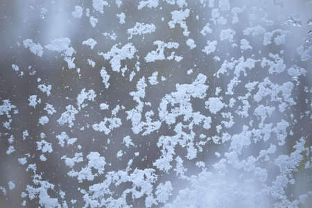 Cold weather and snow storm view from inside home. Window covered with snow