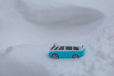 Light blue camper bus stuck in the snow